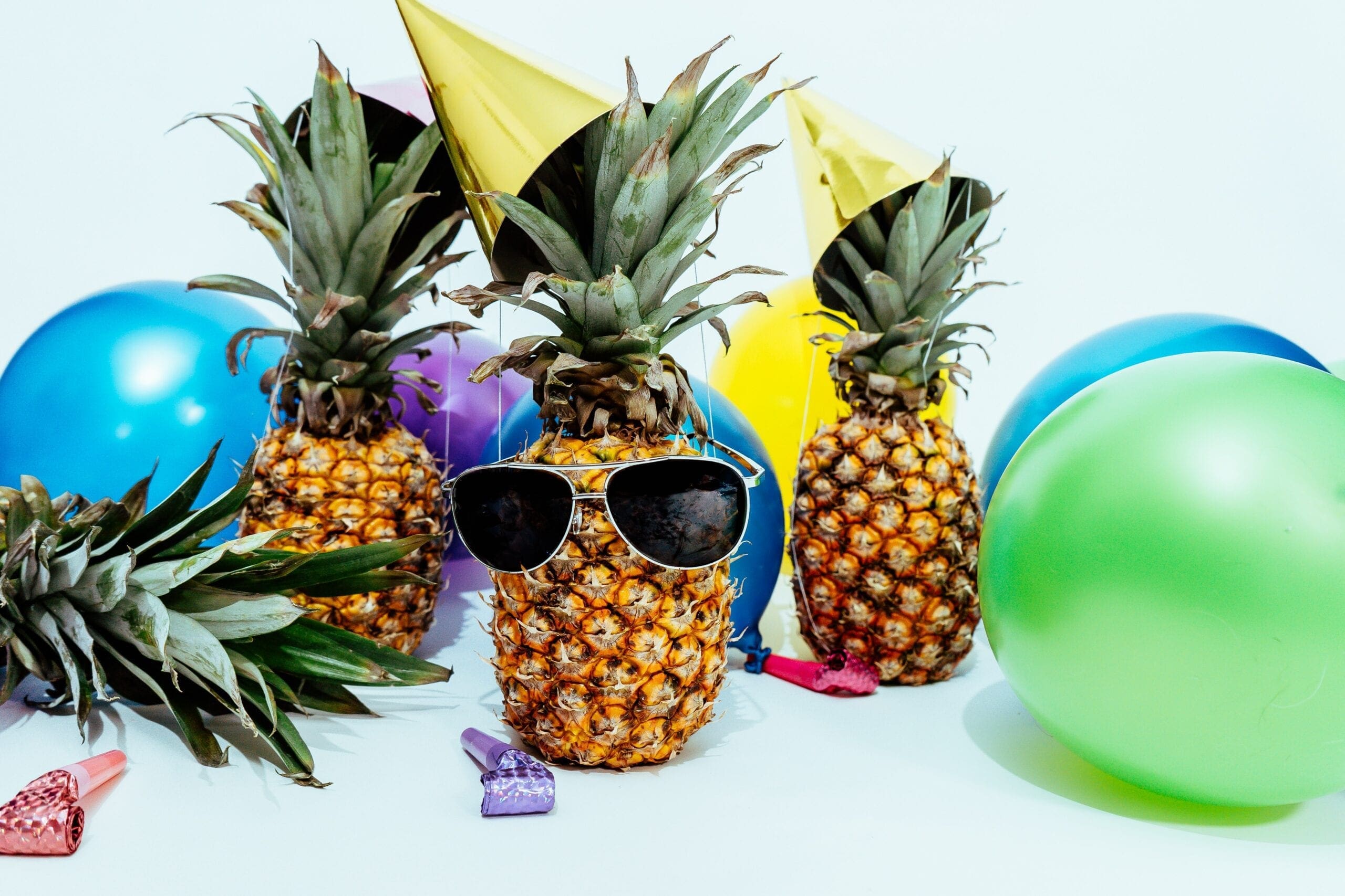 Pineapples dressed up and celebrating and having a party. The SpeakEasy Cooperative is four years old please celebrate with us