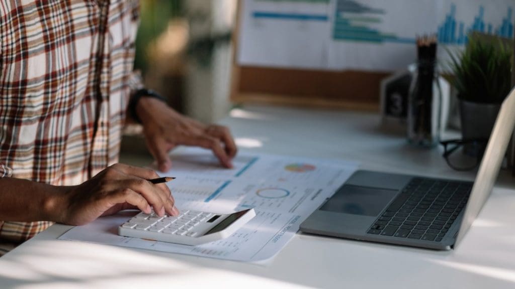 A business owner calculating data in front of a computer.