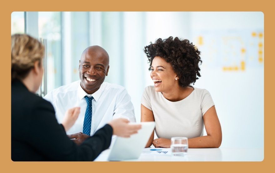 A photo demonstrating strong client relationships, showing two happy clients in a meeting with their coach after flexible payment options reduced their financial stress.